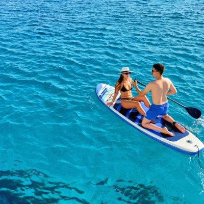 Guests paddleboarding on calm blue water during a DanEri cruise